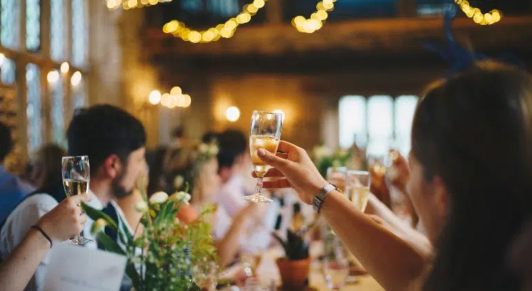 A crowd raising champagne glasses at a wedding at Canareef Resort Maldives