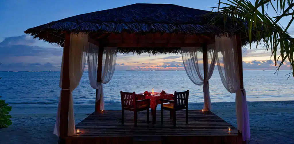 A set-up of a romantic meal at the beach of Canareef Resort