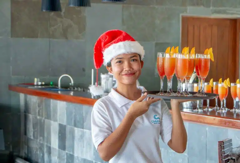 A server holding a tray of drinks at Canareef Resort Maldives