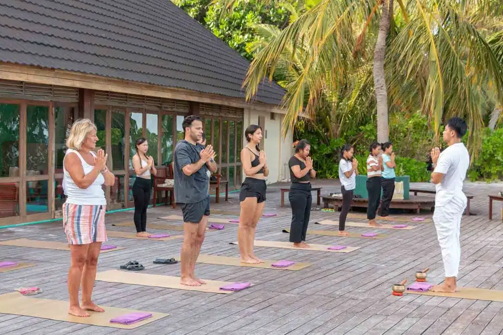 People doing yoga at Canareef Resort Maldives