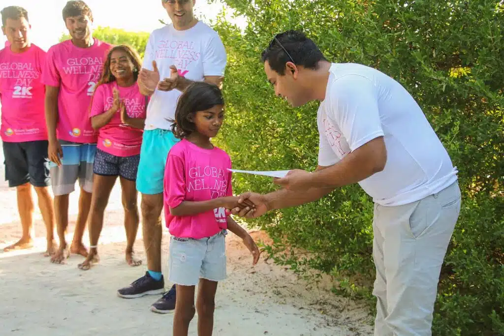 A child receiving an award at Canareef Resort Maldives