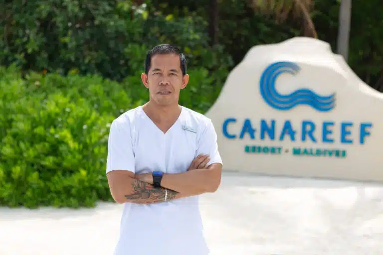 A staff member at the entrance of Canareef Resort Maldives