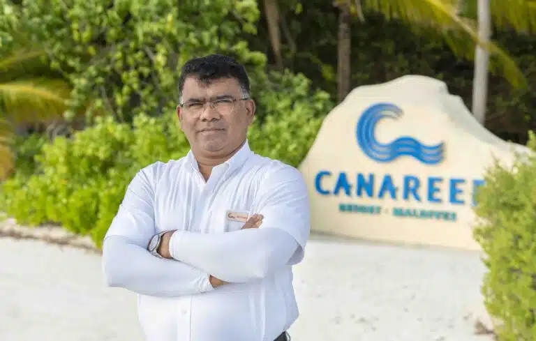 A staff member at the entrance of Canareef Resort Maldives