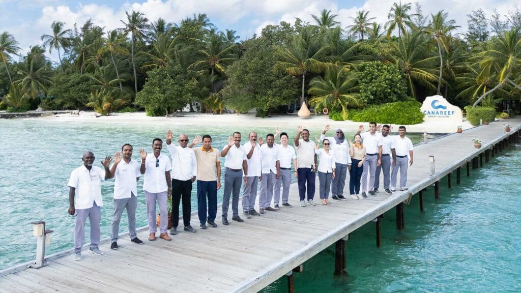The official resort management and staff team at Canareef Resort Maldives posing together on the island.